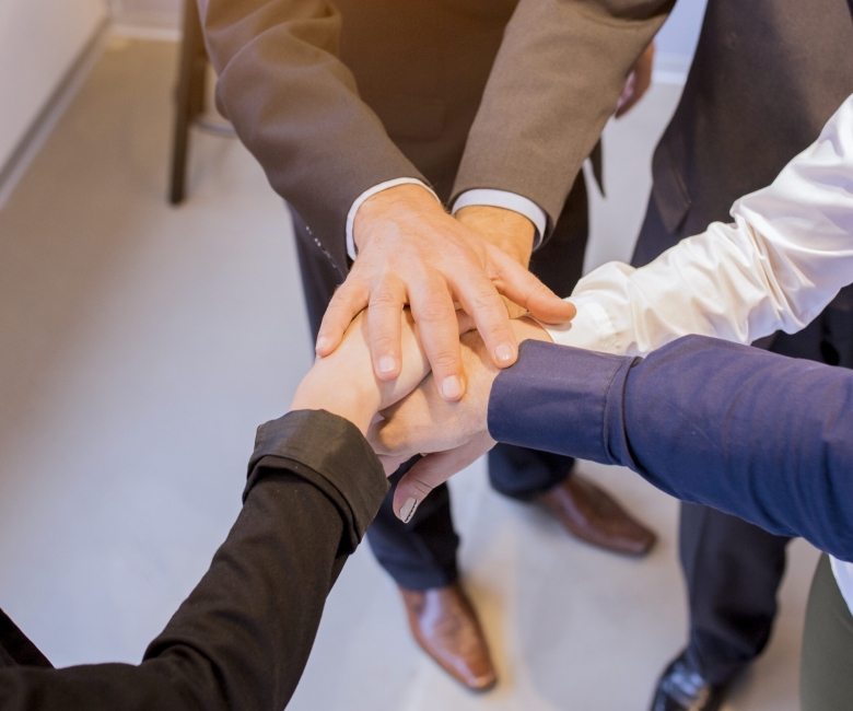 close-up-businesspeople-stacking-hands-meeting-office